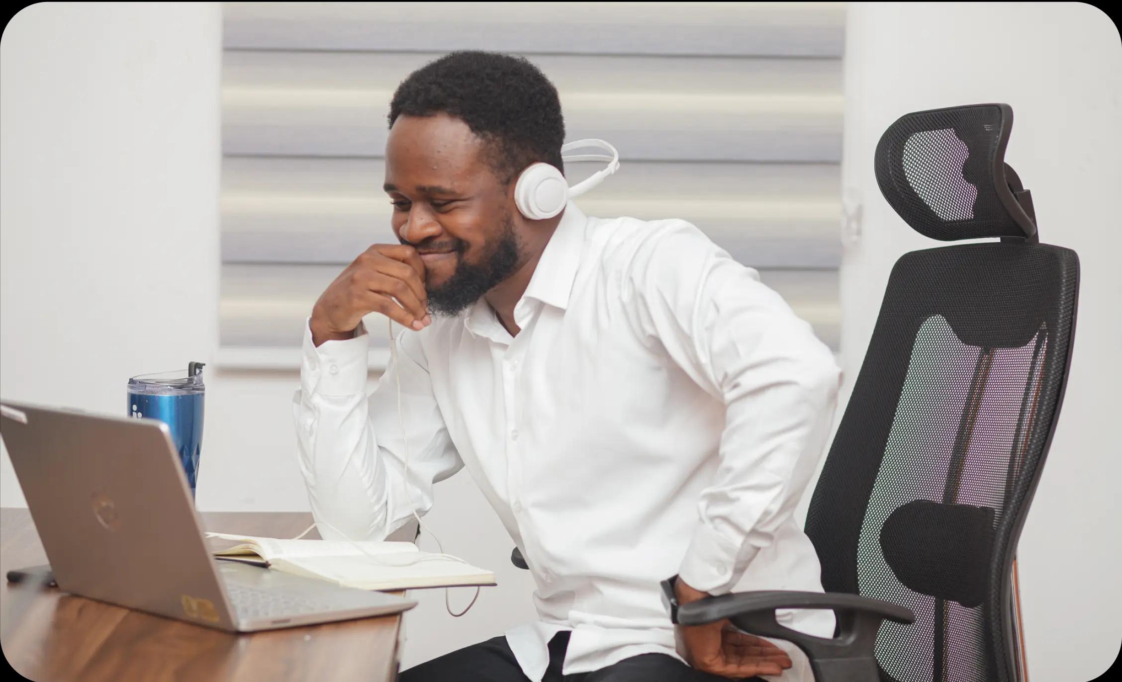 man with headphones smiling at screen